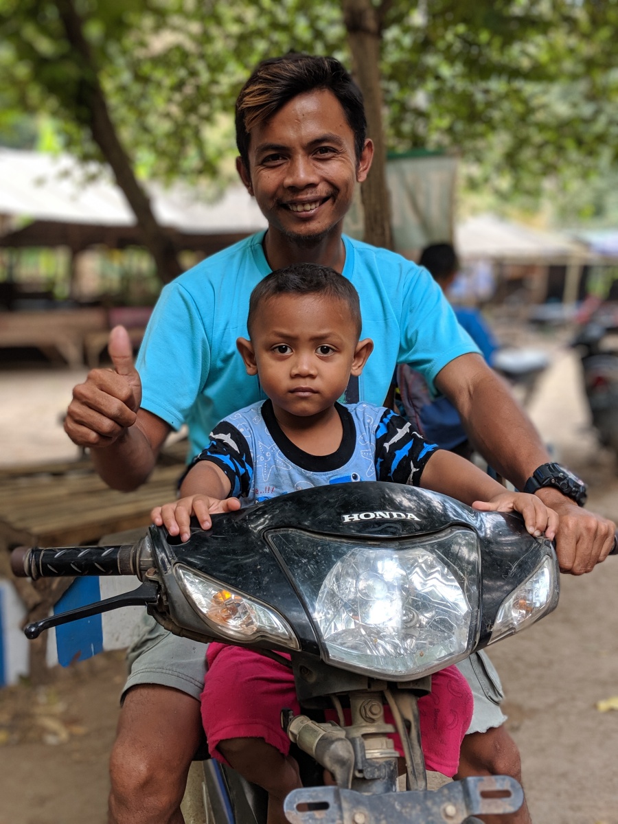 A man and his son on a scooter in Indonesia